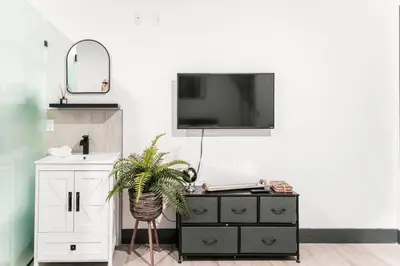 a room with a dresser and a tv on a wall at Discover NYC in stylish Studio-25 mins to NYC in West New York