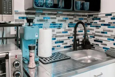 a kitchen sink with a roll of paper towels at Discover NYC in stylish Studio-25 mins to NYC in West New York