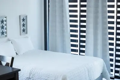 a bedroom with a white bed and a window at Stylish Studio Apt-Outside NYC in West New York