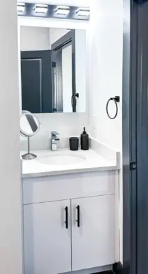 a bathroom with a white sink and a mirror at Stylish Studio Apt-Outside NYC in West New York