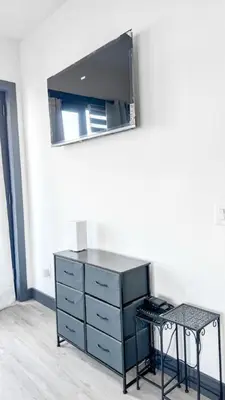 a dresser with a mirror and a table in a room at Stylish Studio Apt-Outside NYC in West New York