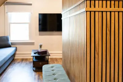 a living room with a blue couch and a tv at Bright, Cozy, and Peaceful Two Bedroom Apt Near NYC in North Bergen