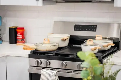 a kitchen stove with three pots and pans on it at City Adventure-Quick NYC Access-2BR-Free Parking in West New York