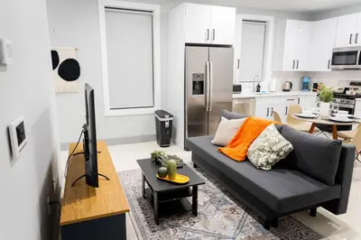 a living room with a couch and a kitchen at City Adventure-Quick NYC Access-2BR-Free Parking in West New York