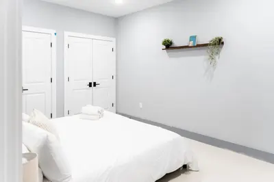 a white bedroom with a bed and white walls at Quick NYC Access with Free Parking Two Bedrooms Near NYC in West New York