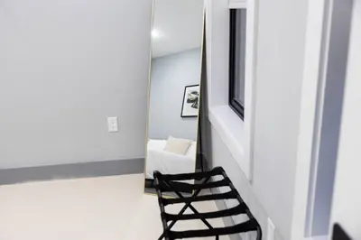 a black chair in a room with a mirror at Quick NYC Access with Free Parking Two Bedrooms Near NYC in West New York