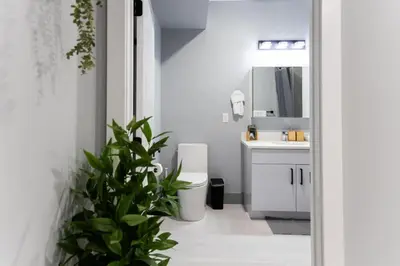 a white bathroom with a toilet and a sink at Quick NYC Access with Free Parking Two Bedrooms Near NYC in West New York