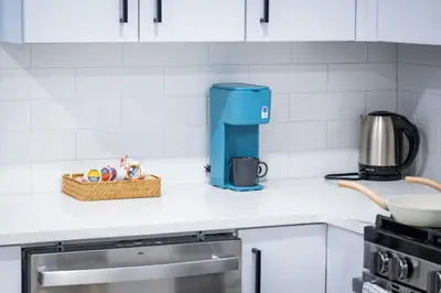a kitchen counter with a coffee maker and a basket on it at Bright Apartment with Free Parking Near NYC in West New York