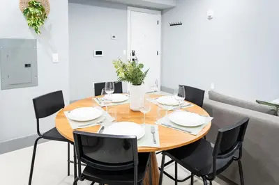 a dining room with a wooden table and black chairs at Bright Apartment with Free Parking Near NYC in West New York