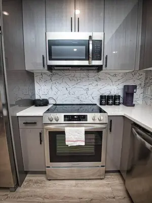 a kitchen with a stainless steel stove and a microwave at Prime Location with Free Parking Near NYC in West New York