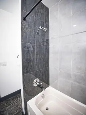 a bathroom with a white tub and a shower at Prime Location with Free Parking Near NYC in West New York