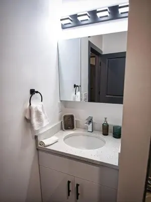 a bathroom with a sink and a large mirror at Prime Location with Free Parking Near NYC in West New York
