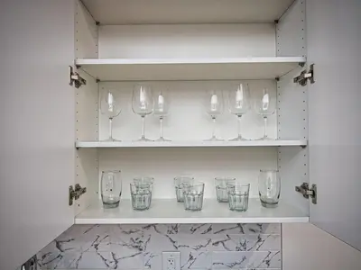 a row of empty glasses sitting on a shelf at Prime Location with Free Parking Near NYC in West New York