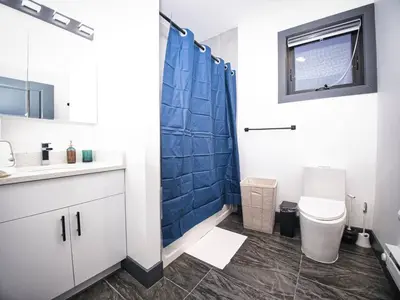 a bathroom with a toilet and a blue shower at Prime Location with Free Parking Near NYC in West New York