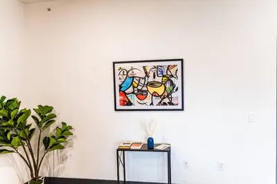 a picture hanging on a white wall with a table at Two Bedrooms with Free Parking Near NYC in West New York