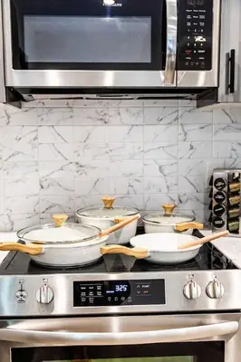 a group of pans sitting on top of a stove at Two Bedrooms with Free Parking Near NYC in West New York