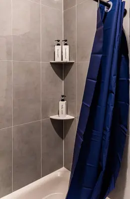 a bathroom with a blue shower curtain and a tub at Two Bedrooms with Free Parking Near NYC in West New York