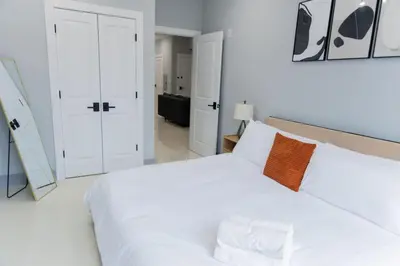 a white bedroom with a large white bed with two pillows at Easy Access to Times Square and Metlife Stadium Free Parking in West New York
