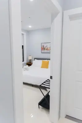 a bedroom with a bed in a white room at Easy Access to Times Square and Metlife Stadium Free Parking in West New York