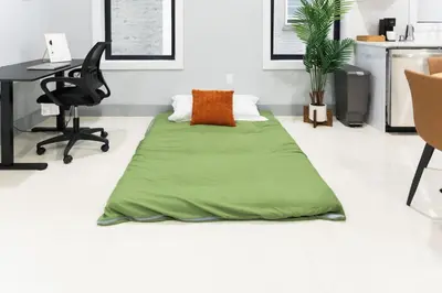 a green blanket laying on the floor in a room at Easy Access to Times Square and Metlife Stadium Free Parking in West New York