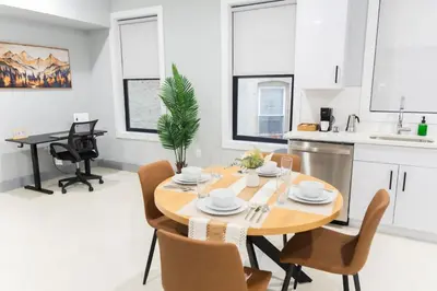 a kitchen and dining room with a wooden table and chairs at Easy Access to Times Square and Metlife Stadium Free Parking in West New York