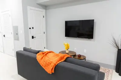a living room with a couch with an orange blanket on it at Easy Access to Times Square and Metlife Stadium Free Parking in West New York