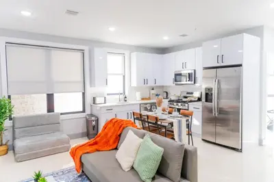 a living room with a couch and a kitchen at Modern 1 Bedroom Apt with Quick NYC Access and Free Parking in West New York
