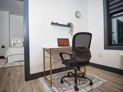 a desk with a chair in a room with a bed at Explore New York City-20 Minutes Away With Parking in West New York