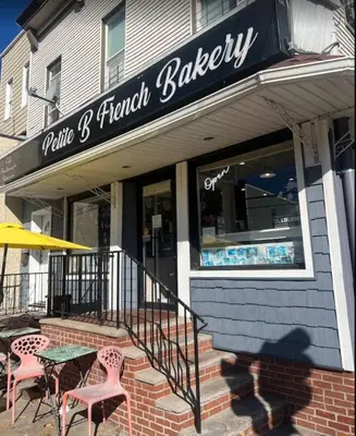 a bakery with tables and chairs in front of a building at Explore New York City-20 Minutes Away With Parking in West New York