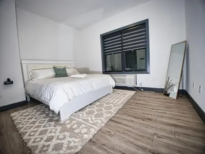 a bedroom with a bed and a large window at Explore New York City-20 Minutes Away With Parking in West New York