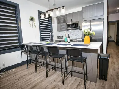a kitchen with a island with bar stools at Great Location-20 Mins to NYC-Free Indoor Parking in West New York