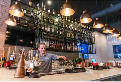 a man preparing a drink at a bar at Great Location-20 Mins to NYC-Free Indoor Parking in West New York