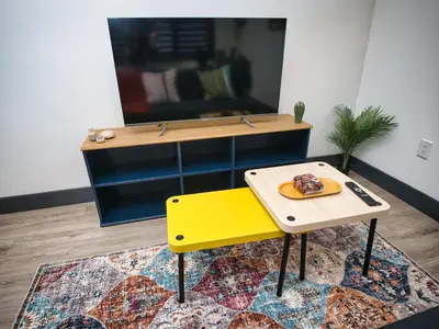 a table and a yellow bench in a room at Great Location-20 Mins to NYC-Free Indoor Parking in West New York