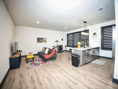a living room with a couch and a table and a kitchen at Great Location-20 Mins to NYC-Free Indoor Parking in West New York