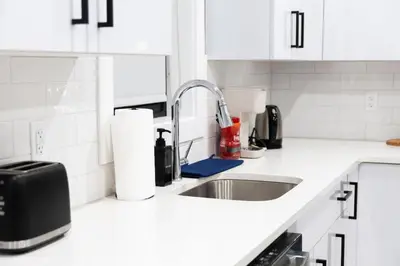 a white kitchen with a sink and a microwave at 2 Bedroom Apt-City Adventure-Free Parking on Site in West New York
