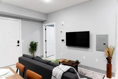a living room with a couch and a tv on a wall at 2 Bedroom Apt-City Adventure-Free Parking on Site in West New York