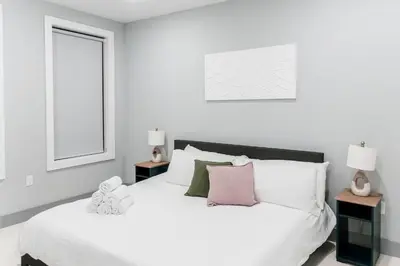 a white bedroom with a large white bed with pillows at 2 Bedroom Apt-City Adventure-Free Parking on Site in West New York