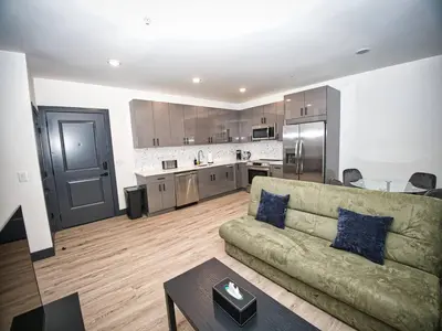 a living room with a couch and a kitchen at Free Indoor Parking 25 Minutes to NYC in West New York