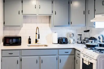 a white kitchen with white cabinets and a sink at Spacious 2-Bedroom Apartment NYC-10 mins away in Union City