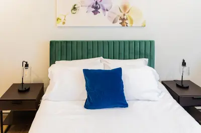 a bed with a blue pillow on top of it at Spacious 2-Bedroom Apartment NYC-10 mins away in Union City