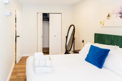 a bedroom with a white bed and a mirror at Spacious 2-Bedroom Apartment NYC-10 mins away in Union City