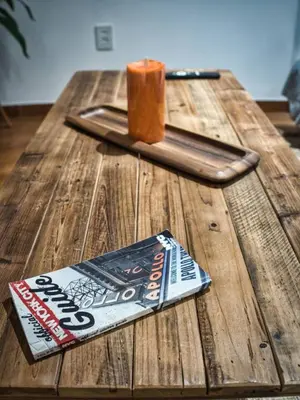 a wooden table with a book and a candle on it at Cozy Apt With King Size Bed- Only 5 Miles to NYC in North Bergen