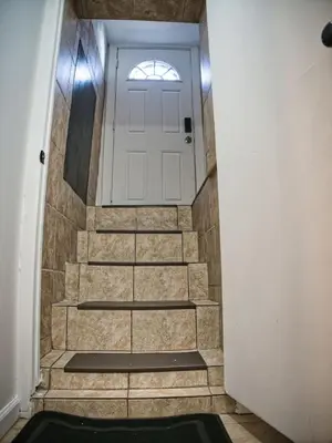 a hallway with a white door and a set of stairs at Cozy Apt With King Size Bed- Only 5 Miles to NYC in North Bergen