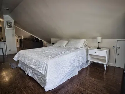a bedroom with a white bed and a night stand at Comfy 3rd Floor Studio Near NYC in Ridgefield Park