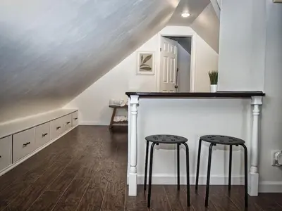 a staircase with two stools in a room with white walls at Comfy 3rd Floor Studio Near NYC in Ridgefield Park