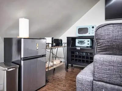 a living room with a refrigerator and a couch at Comfy 3rd Floor Studio Near NYC in Ridgefield Park