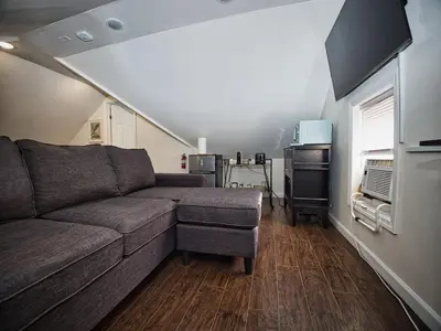 a living room with a couch and a window at Comfy 3rd Floor Studio Near NYC in Ridgefield Park