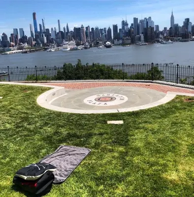 a blanket laying on the grass with a view of the city at Private Suite Hudson River View in Union City