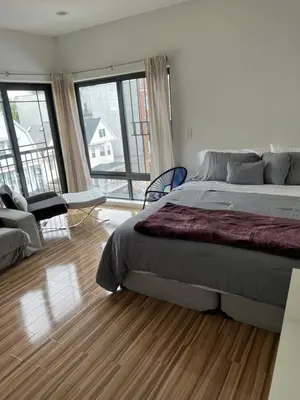 a bedroom with a large bed and a living room at Private Suite Hudson River View in Union City