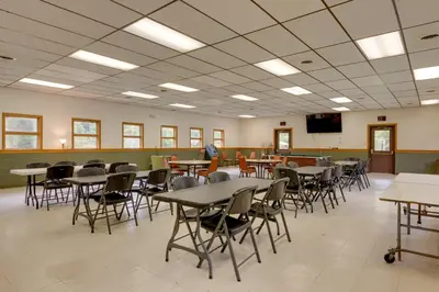 a class room with tables and chairs and a tv at Deluxe Cabin D at Elk Creek Escape! Pets Welcome in Hillsgrove
